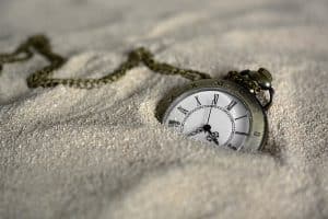 What is hypnotherapy used for? Aiding grief handling. A fob watch in the sand.