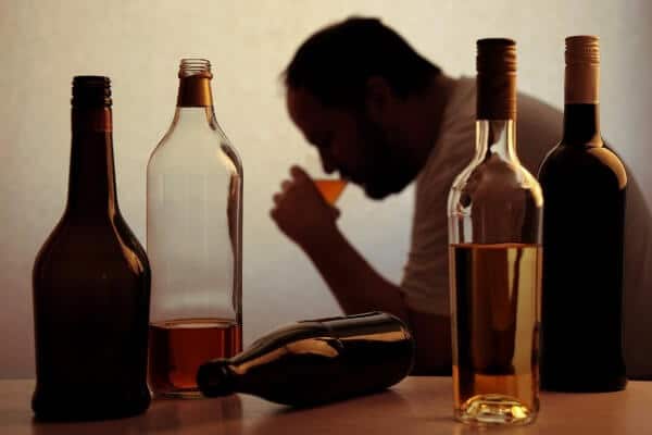 Silhouette of a man drinking alcohol due to social anxiety