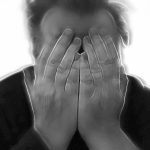 Man with hands over face - hypnotherapy training for healthcare professionals