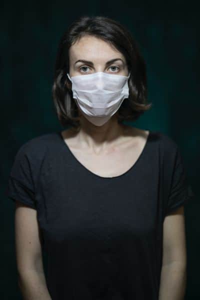 Masked hypnotherapist - woman with a white mask and black t-shirt and background.