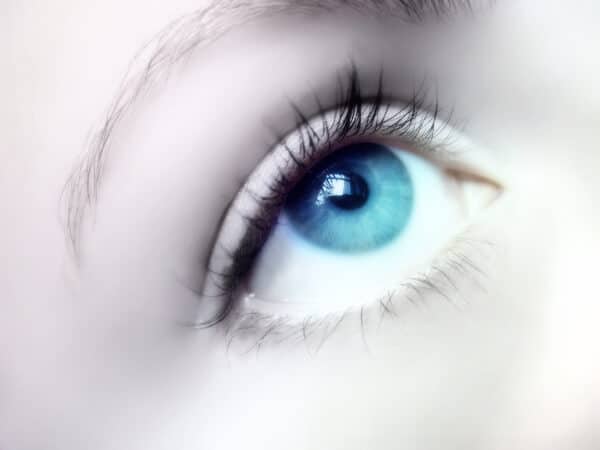 a female eye, looking up towards a focal point during an eye fixation hypnotic induction