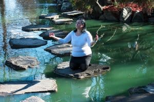 Woman kneeling on a stone in a pond - Antisocial personality disorder and hypnotherapy